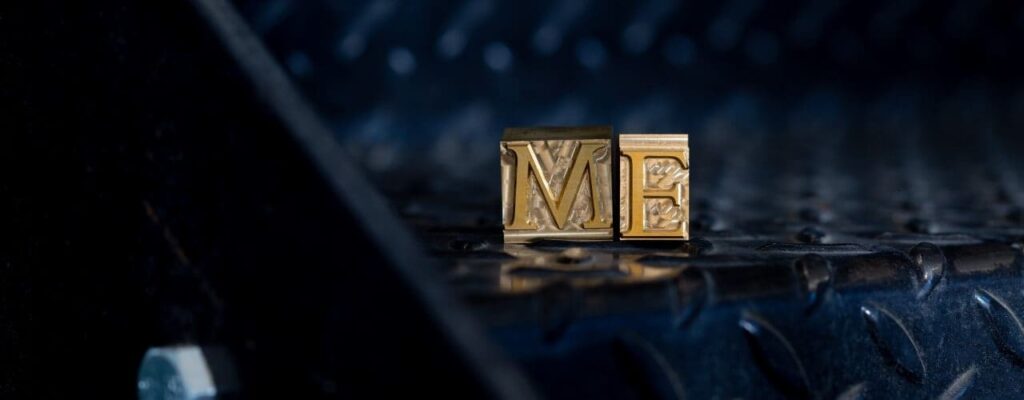 Brass type spelling "ME" sat on black metal stairs