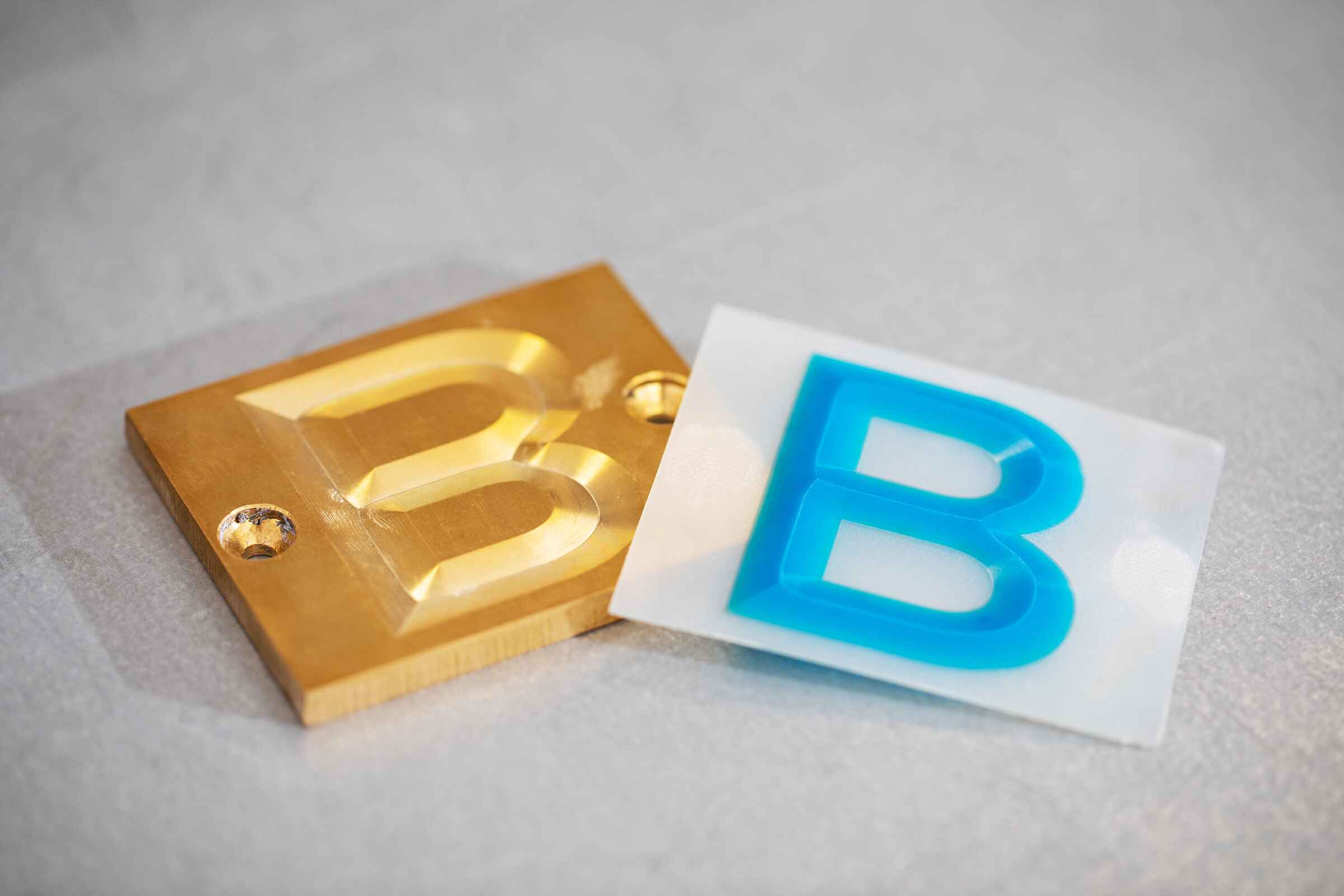 An image of 2 plates, one brass and one polymer