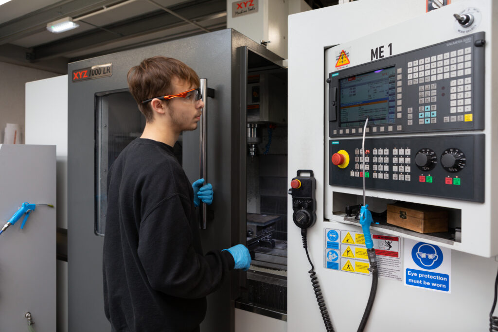 Man operating a CNC machine looking at a screen