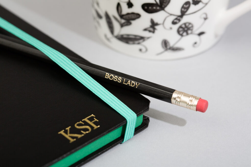 Close up of custom printed pencil and notebook with gold foil