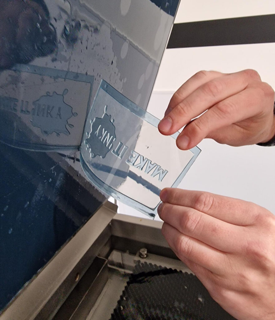 Man removing letterpress plates from a clear sheet