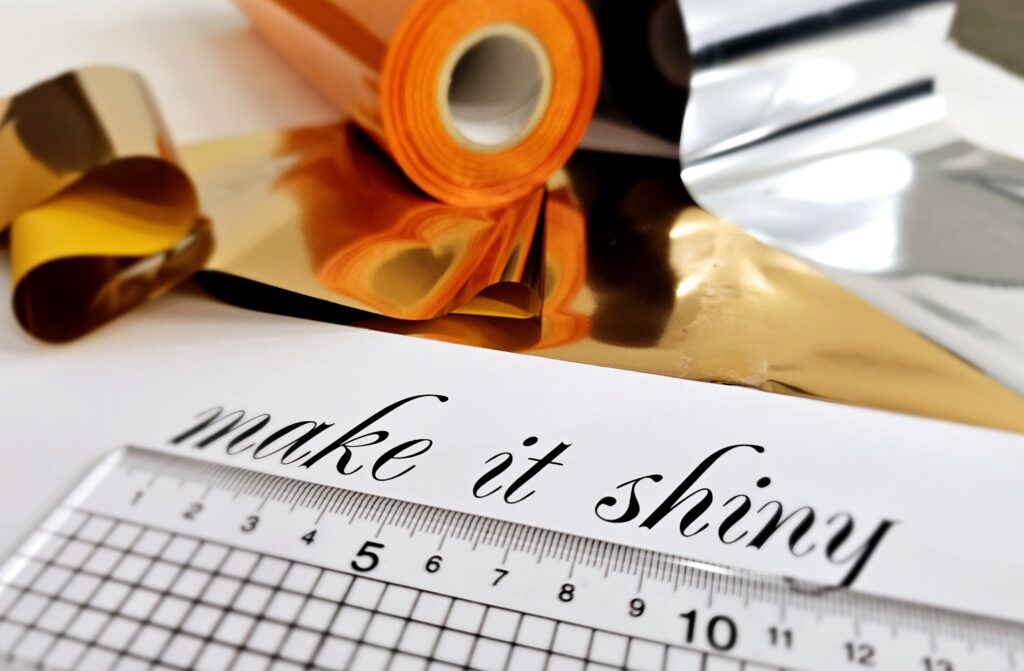 Close up of artwork being measured with foil rolls sitting next to it