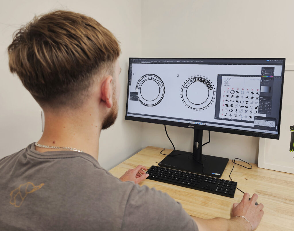 Man using a computer to create custom rosette artwork