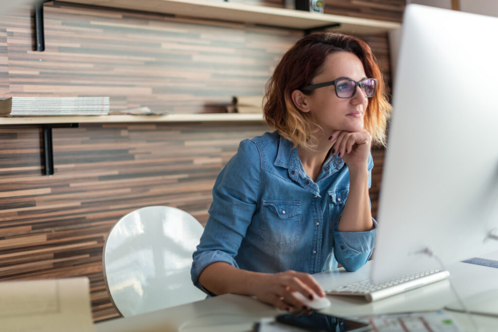 Woman sitting at a desk looking at a computer screen