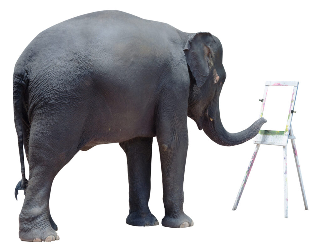 An elephant painting on a blank sheet of paper on an easel