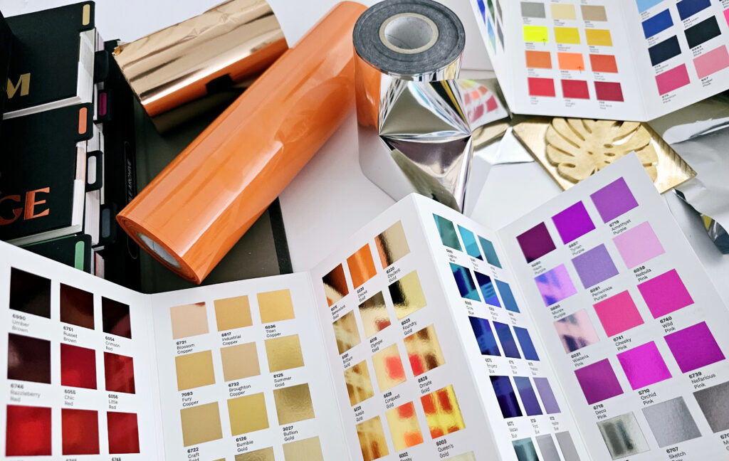 A collection of foil samples on folded white card