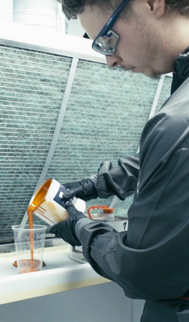 Man mixing paint in a plastic cup