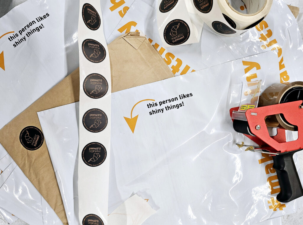 A roll of circular stickers unraveled over postage bags